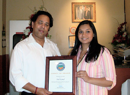 Nelson Staffer Neha Sata presenting Neel Kamal owner with a Certificate of Recognition