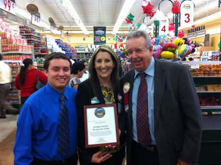 Nelson staffer Neha Sata presents Sprouts Photography in Fullerton with a Certificate for their Ribbon Cutting.