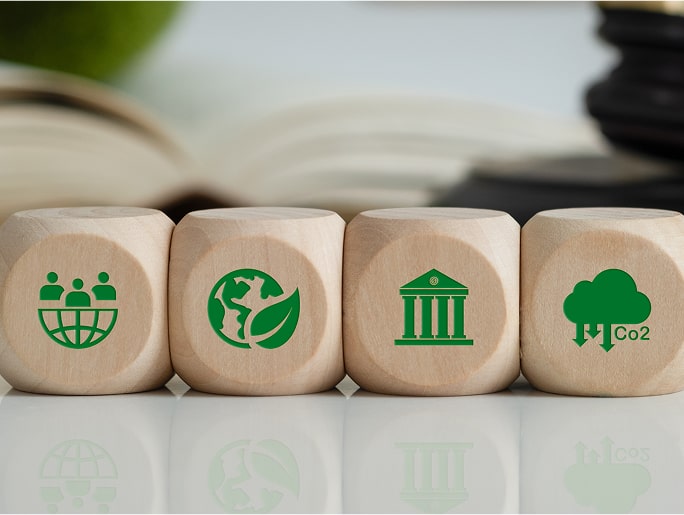 Wooden blocks with icons for community, environment, policy, and CO2 reduction